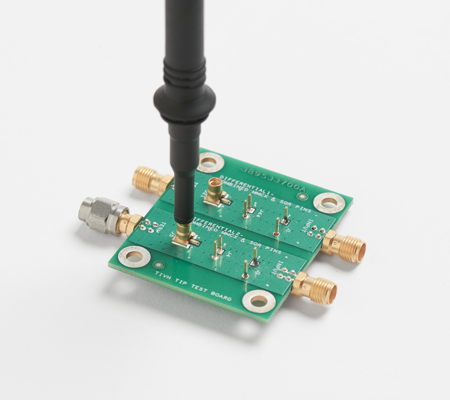 PCB test board with exposed measurement points and oscilloscope probe connection